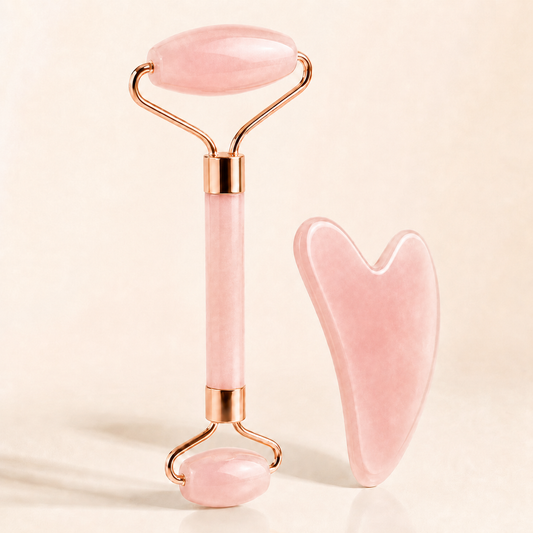 Pink facial roller and gua sha tool on a beige background